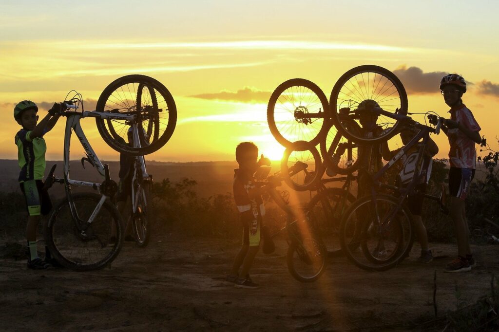 Familie mit Kindern und Fahrrädern bei Sonnenuntergang